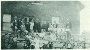 group of people seated and standing near brick wall