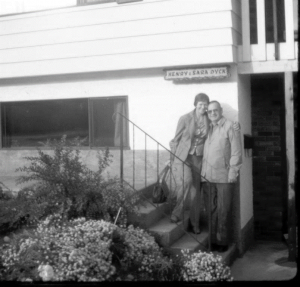 Man and woman standing on stairs in front of their home