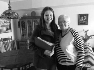 young woman standing next to older woman with arms around each other's shoulders