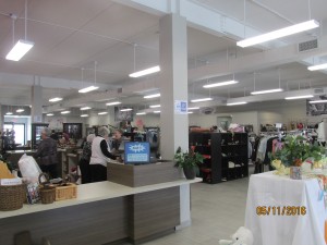 Donated items and clothing for sale on shelves and racks