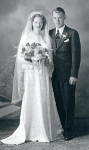 Wedding portrait of woman in white dress with bouquet of flowers and man in a dark suit